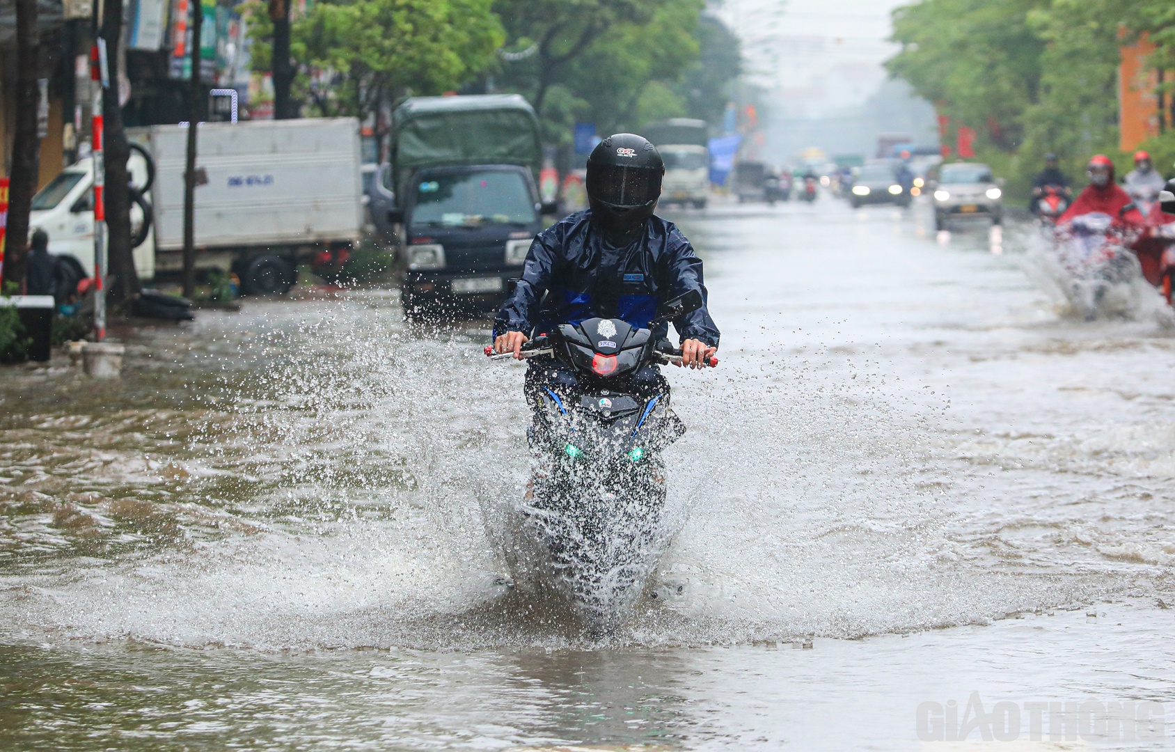 Hình ảnh người dân "rẽ sóng" băng qua đoạn đường ngập.
