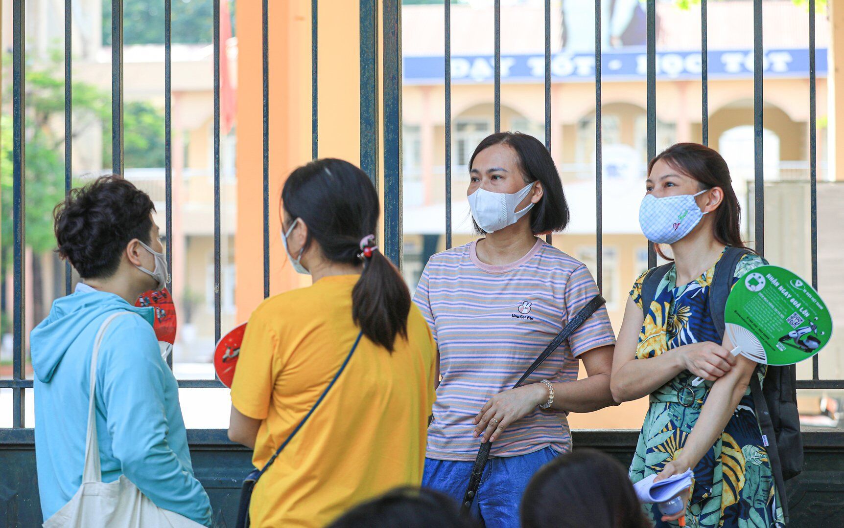 Dưới tiết trời nắng nóng như đổ lửa, nhiều phụ huynh vẫn nán lại cổng trường chờ đợi trong khi các sĩ tử đang tập trung cho bài thi đầu tiên - Ngữ văn.