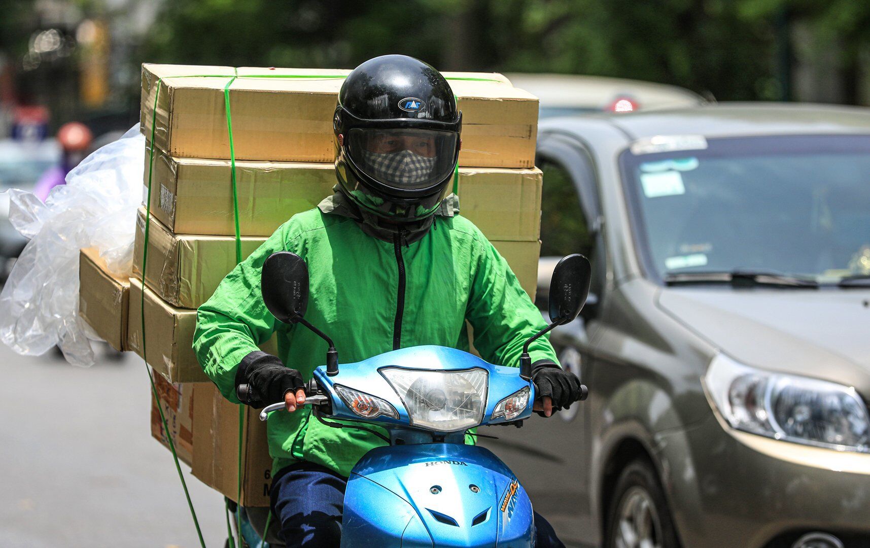 Ông Lộc - người hành nghề shipper cho biết, hai hôm trở lại đây, ông đội thêm khăn dưới lớp mũ bảo hiểm vì không chịu nổi khi di chuyển dưới nắng nóng liên tục.