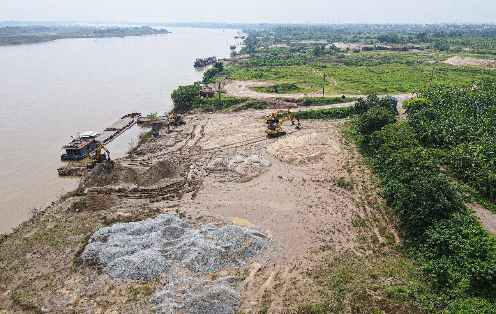 Rất nhiều máy xúc được tập kết tại đây để sẵn sàng hoạt động sang tải cát, sỏi lên bãi tập kết vật liệu.