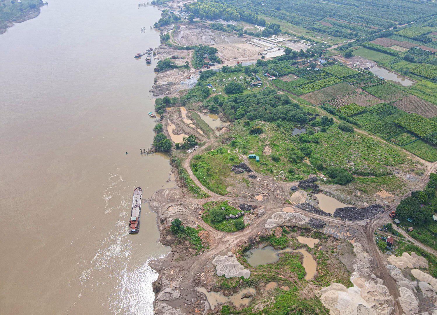 Cuối tháng 5/2022, vừa qua Báo Giao thông đã phản ánh hiện tượng hàng chục nghìn mét vuông đất tại khu đất bãi sông Hồng, đoạn qua địa phận xã Vĩnh Ngọc (huyện Đông Anh, TP Hà Nội), bị "băm nát" bởi nhiều bãi tập kết vật liệu, trạm trộn bê tông hoạt động rầm rộ.