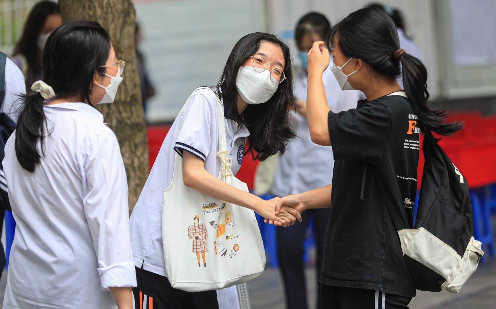 Cái bắt tay, động viên cùng nhau vượt qua kỳ thi đầy cam go của hai nữ sinh.