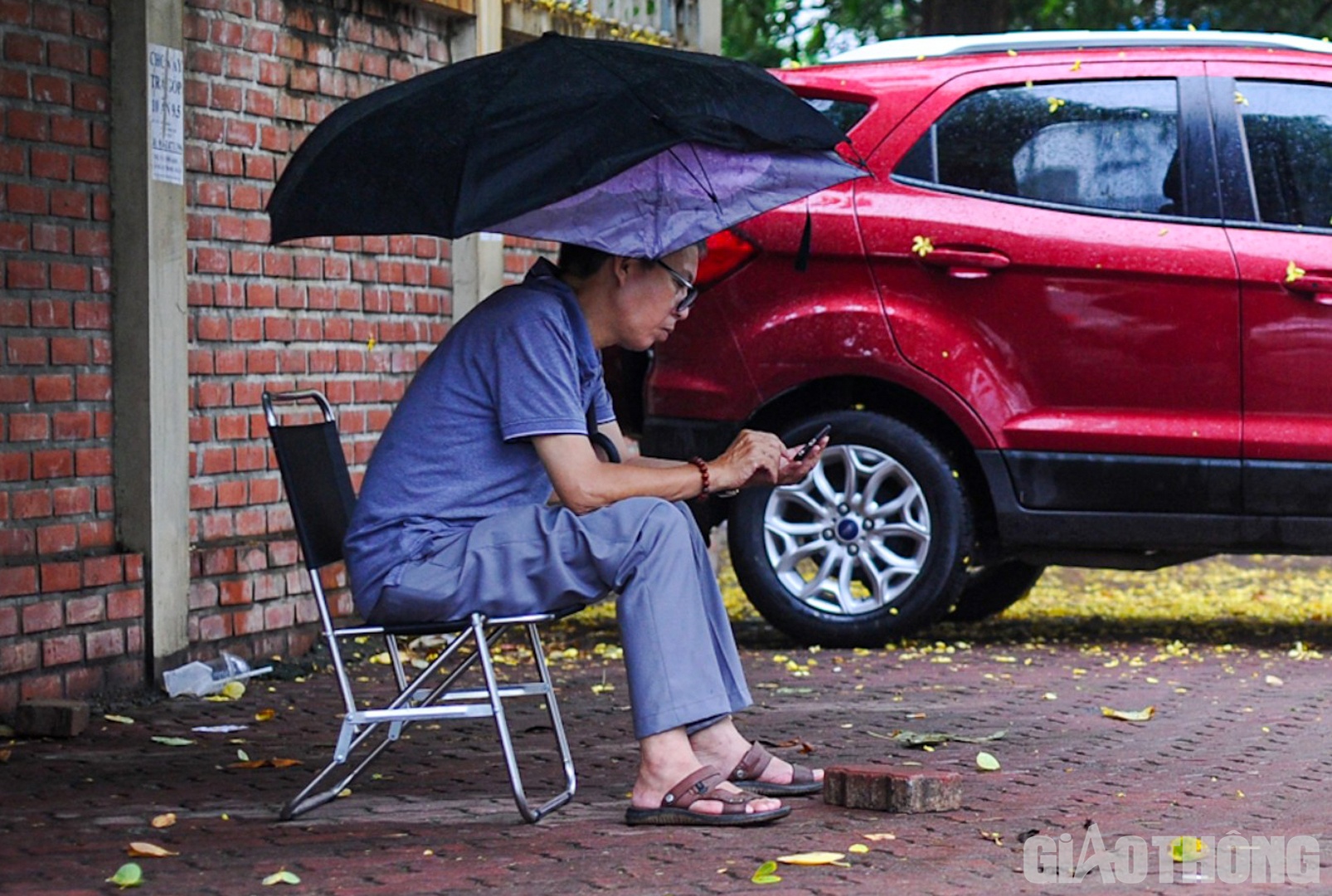 Tìm một chỗ trú mưa dưới tán cây, anh Lê Anh Tuấn (quận Tây Hồ) cho hay: "Giờ về cũng sốt ruột nên tôi quyết định đợi ở bên ngoài cổng trường thi cũng như để tiếp thêm tinh thần cho con làm bài được tốt hơn".