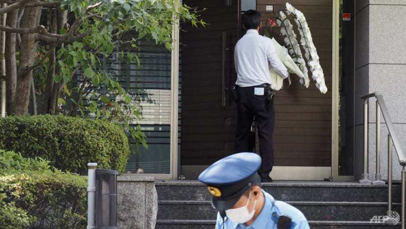 Nhân viên đưa lẵng hoa viếng ông Abe Shinzo vào bên trong nhà. Ảnh - AFP