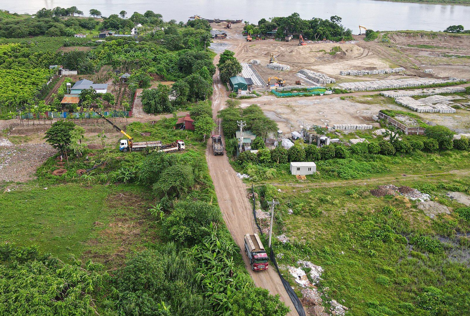 Khi "ăn no" cát, những chiếc xe này sẽ men theo đường đất rồi lên đê sông Hồng.