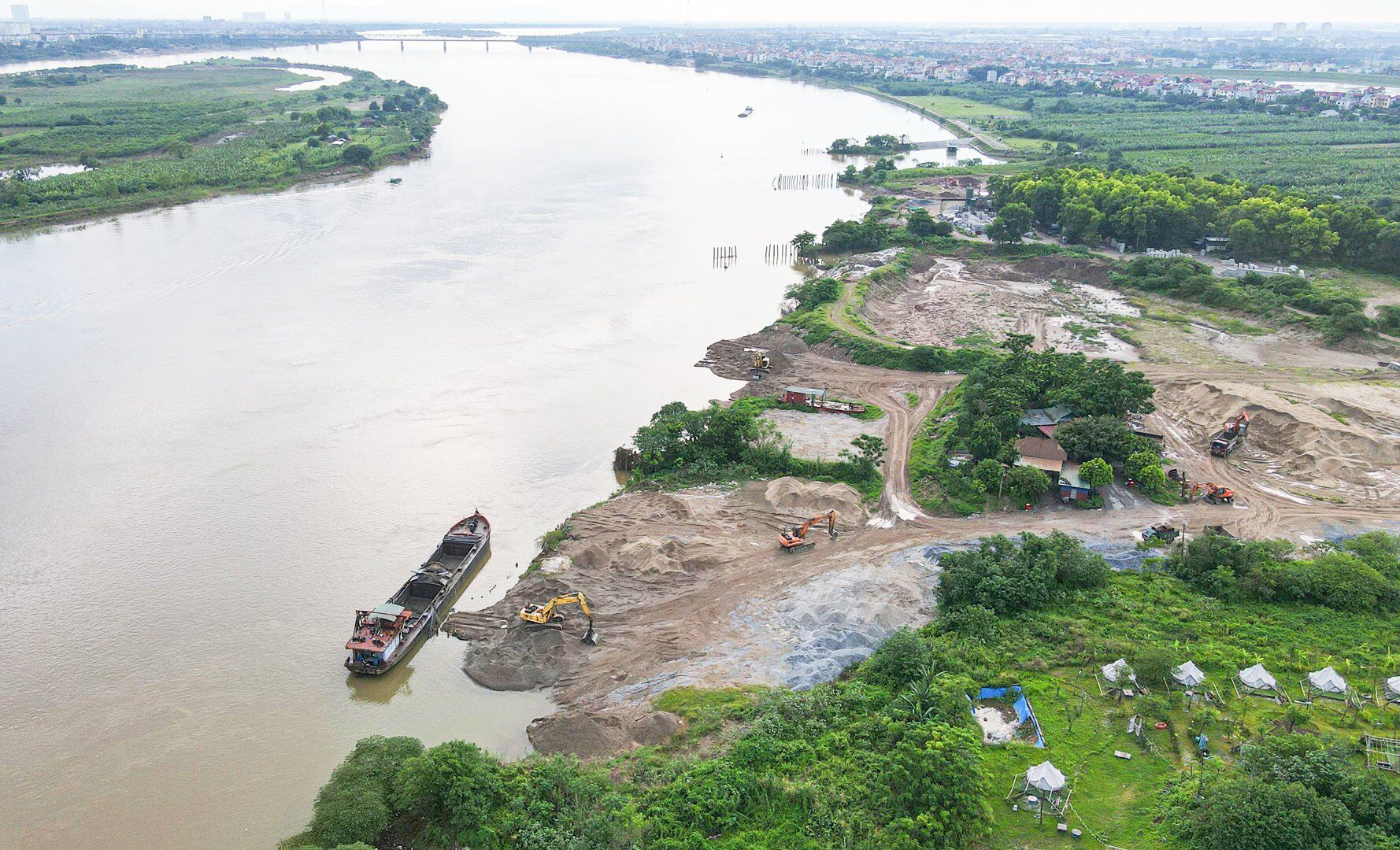 Vừa qua, Báo Giao thông phản ánh hiện tượng bãi tập kết vật liệu xây dựng, trạm trộn bê tông "bức tử" hàng chục nghìn mét vuông đất bãi bồi sông Hồng (đoạn qua địa phận xã Hải Bối, xã Vĩnh Ngọc, huyện Đông Anh, TP Hà Nội). Kèm theo đó là những "binh đoàn" xe có biểu hiện quá khổ, quá tải hoạt động tại đê sông Hồng.
Sau đó, huyện Đông Anh đã chỉ đạo lực lượng chức năng vào cuộc để xử lý dứt điểm hiện tượng này.