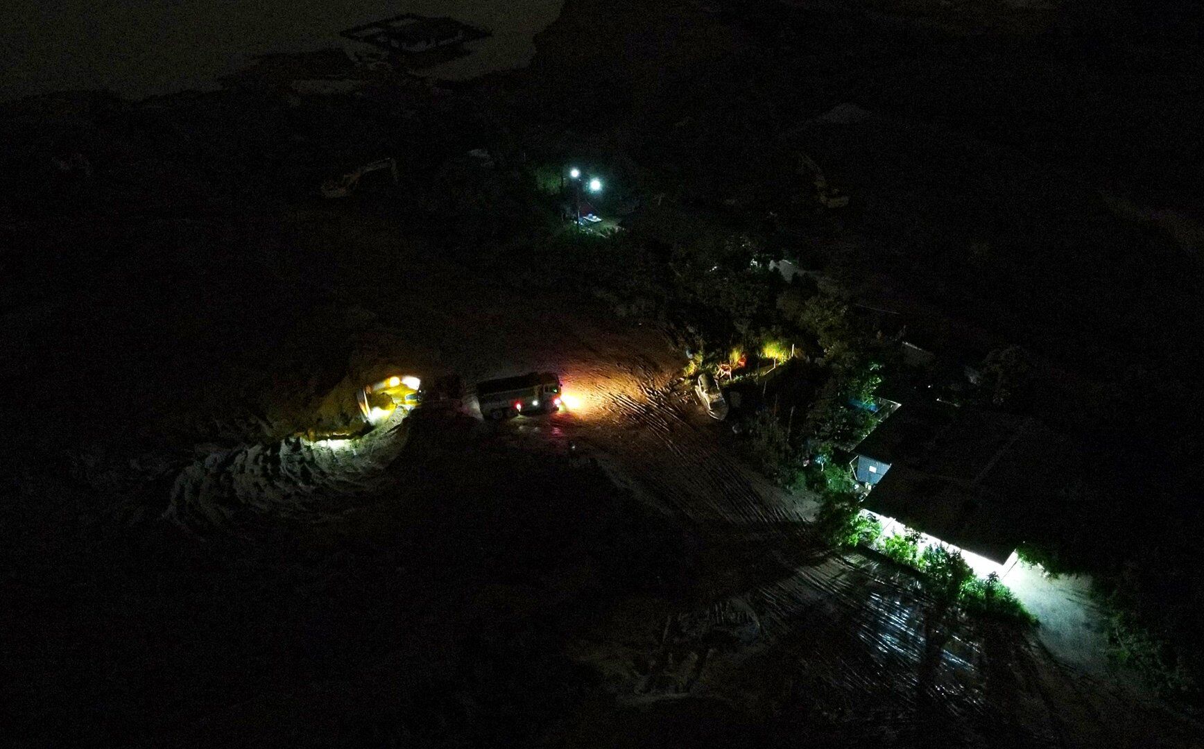 Trong màn đêm, những chiếc máy múc tại những bãi tập kết này "ra sức" múc cát từ bãi tập kết lên những chiếc xe siêu trường, siêu trọng.