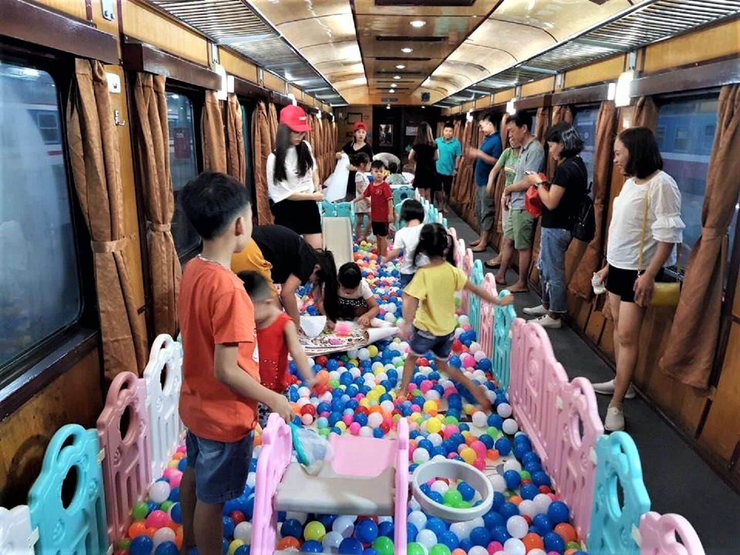 Dịch vụ toa xe cộng đồng được cung cấp cho các đoàn khách có nhu cầu. Trên các toa xe đã tháo hết ghế ngồi này, đường sắt sẽ trang trí, sắp đặt theo yêu cầu của khách hàng, từ tổ chức sinh nhật, khu vui chơi trẻ em đến hát karaoke, khiêu vũ... Ảnh: Hành khách nhí thích thú vui chơi trên tàu