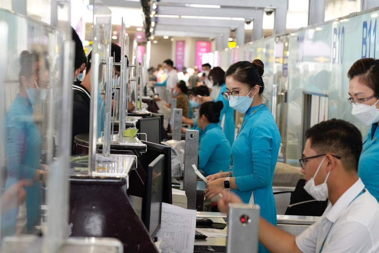 Nhân viên hãng hàng không Vietnam Airlines căng mình làm thủ tục check in cho hành khách tại quầy