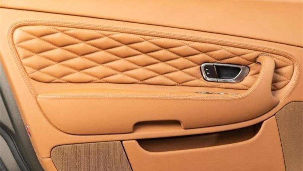 Nổi bật trên bề mặt ốp gỗ nội thất tối màu là chiếc đồng hồ analogue đến từ thương hiệu Breitling