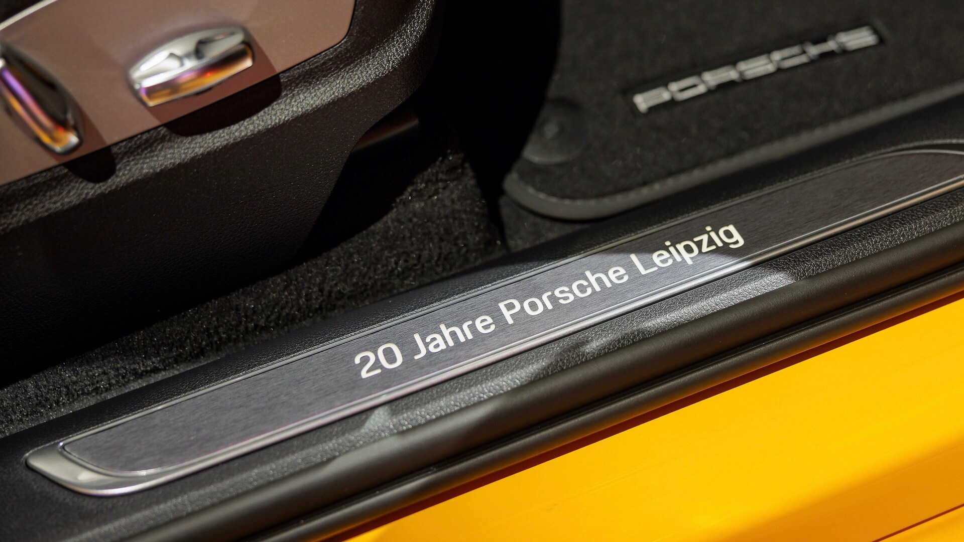 Dòng chữ khắc trên bậc cửa là “Leipziger Opernball 2022” ở một bên xe và dòng chữ “20 Years of Porsche Leipzig” ở phía đối diện