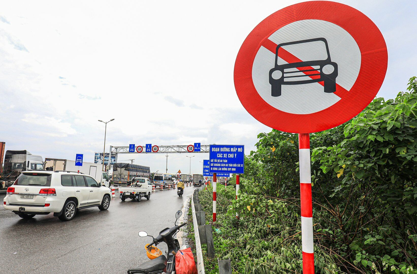 Dù đã có dải phân cách chia làn, biển báo giao thông tách làn xe máy và ô tô, nhưng trên cầu Thanh Trì (TP Hà Nội) vẫn xuất hiện tình trạng ô tô lũ lượt đi vào làn dành riêng cho xe máy.