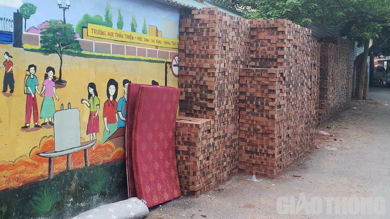 Cụ thể, tại ngõ 342 đường Khương Đình, những đống gạch được xếp cao khoảng hơn 2m nằm rải rác ở mọi vị trí trên đường, thậm chí gạch được xếp cả ở những khu vực tường được vẽ tranh.