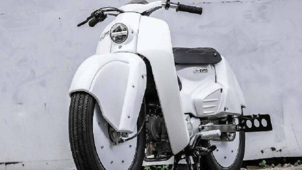 Chiếc xe máy Honda Super Cub độ được trang bị cụm đèn pha tròn mang phong cách cổ điển, cùng với tay lái vuốt cong về phía sau