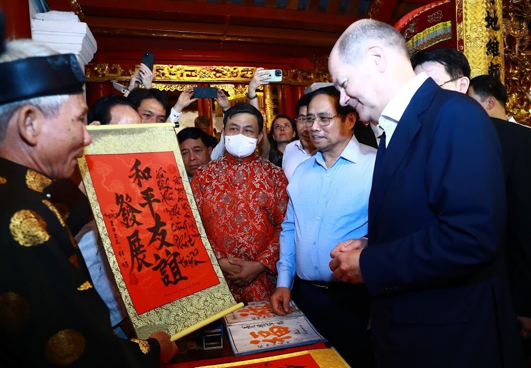 Thầy đồ tại đền Ngọc Sơn tặng bức thư pháp với dòng chữ: "Hòa bình, hữu nghị cùng phát triển" cho Thủ tướng Đức Olaf Scholz - Ảnh: VGP/Nhật Bắc