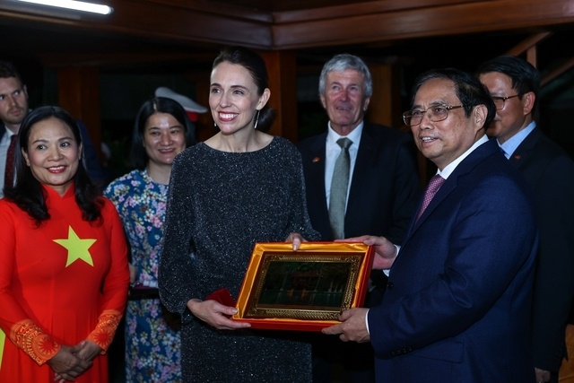 Thủ tướng Phạm Minh Chính tặng Thủ tướng New Zealand bức tranh sơn mài Nhà sàn Bác Hồ. Ảnh - VGP