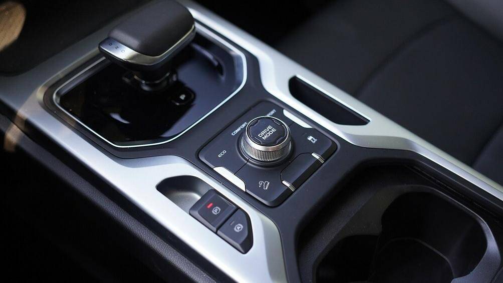 Trên cụm điều khiển trung tâm xuất hiện sạc điện thoại thông minh không dây, cần số ngắn, núm xoay chọn chế độ lái, phanh tay điện tử