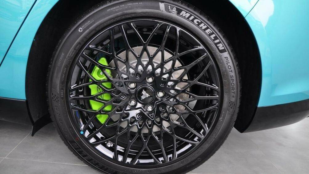 Vành hợp kim 19 inch đa chấu sơn màu đen. Phía sau vành la-zăng còn có cùm phanh màu xanh cốm