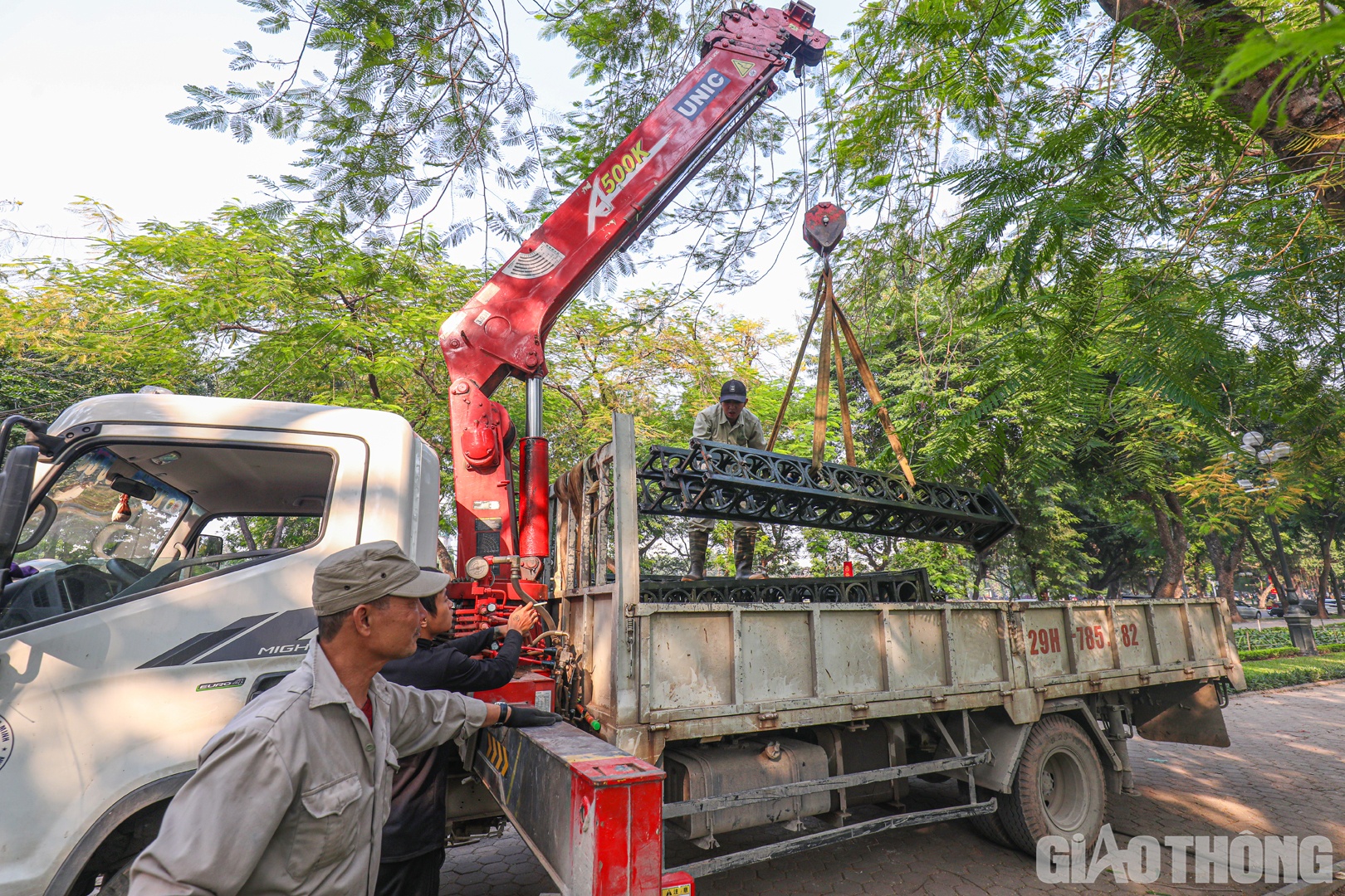Xe cẩu cũng được huy động để vận chuyển trụ và phên hàng rào vừa cắt.