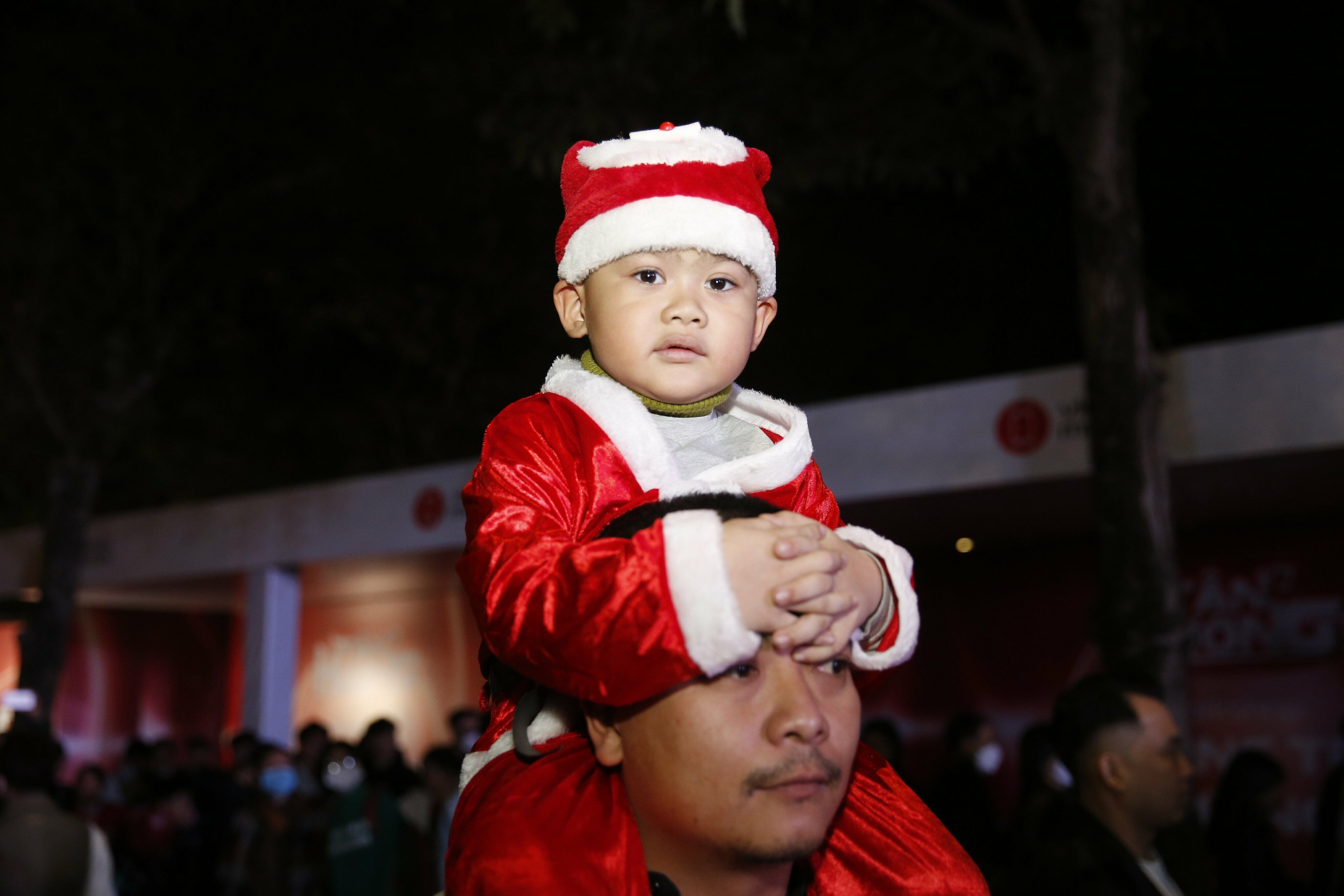 Để di chuyển dễ dàng giữa biển người, những em bé được người thân cõng trên vai.