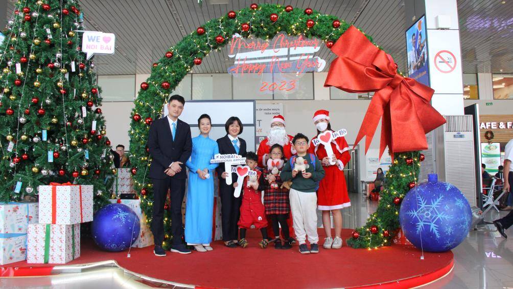 Bà Nguyễn Thị Kim Ngân - Phó Giám đốc Cảng HKQT Nội Bài (thứ ba từ trái sang) tặng quà Giáng sinh cho hành khách nhí