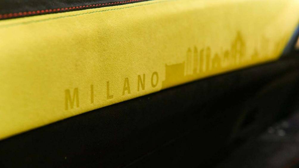 Nắp trên cửa có màu vàng rực rỡ với dòng chữ "Milano" và đường chân trời của thành phố