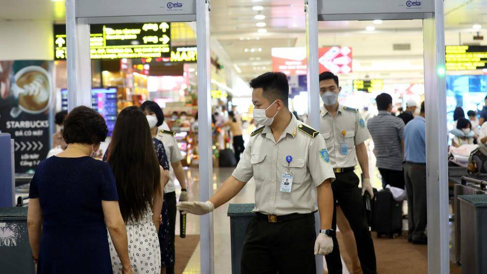 Hành khách khi qua điểm soi chiếu an ninh phải bỏ áo khoác, thắt lưng, giày, điện thoại... ra khay