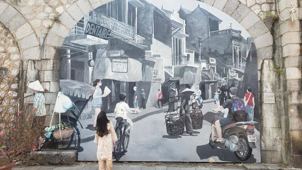 Khu phố bích họa Phùng Hưng những ngày cuối năm đang thu hút rất nhiều người đến chụp ảnh, checkin. Một bé gái dừng lại ngắm rất lâu vào bức tranh phố phường Hà Nội.