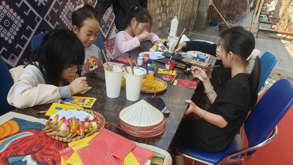 Những bạn trẻ tham gia hoạt động tô màu trên vỉa hè phố bích họa Phùng Hưng.