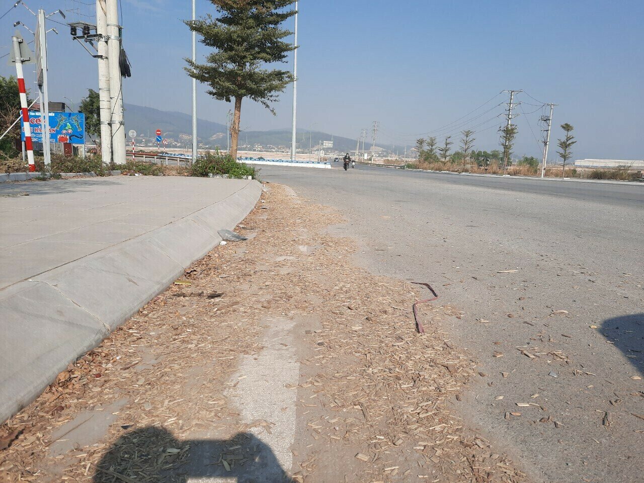 Dăm gỗ rơi xuống thành đống trên Quốc lộ 279 đoạn qua phường Việt Hưng, TP Hạ Long.