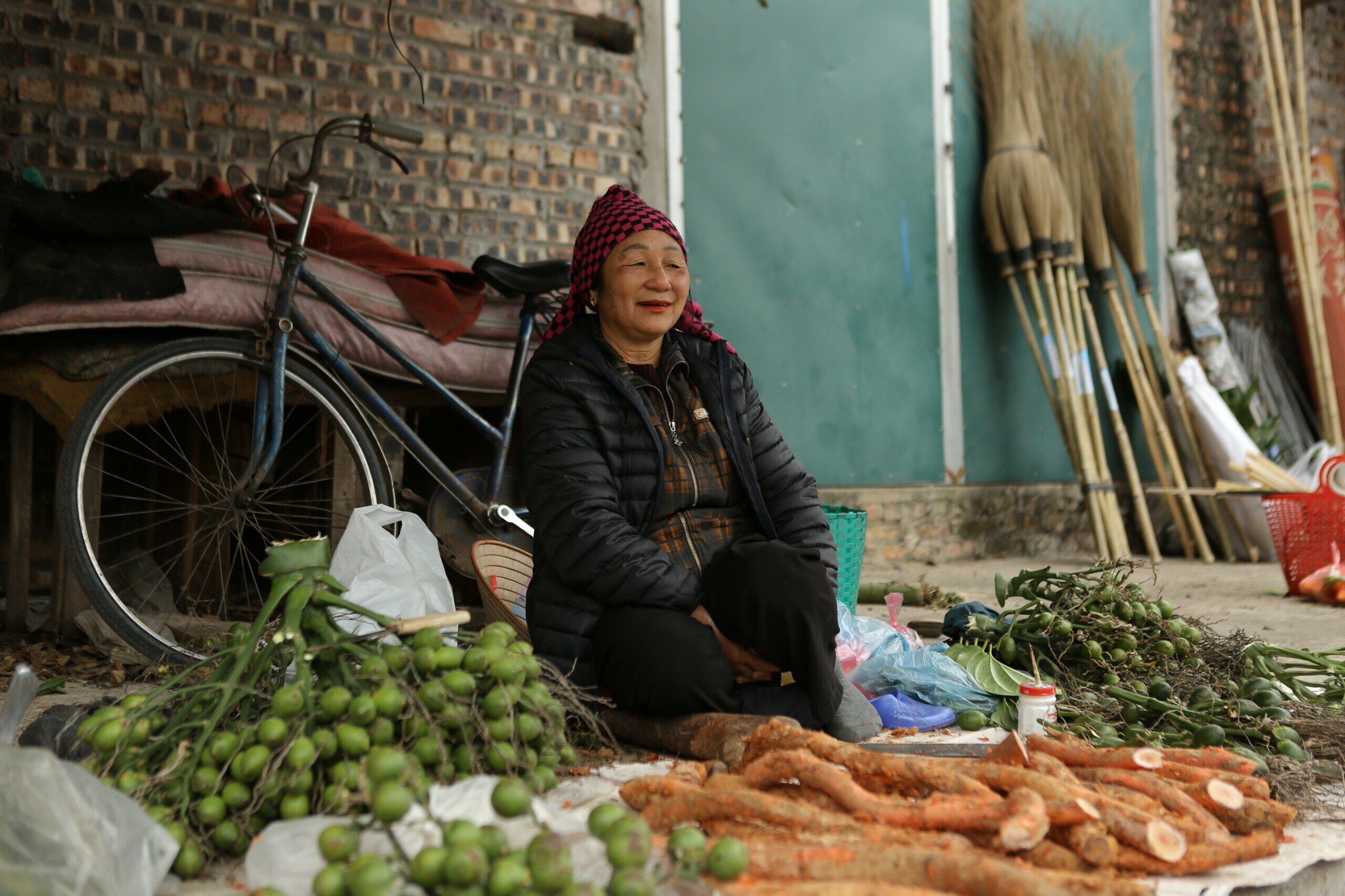 Bà bán trầu cau với khăn chít mỏ quạ, nụ cười tươi tắn.