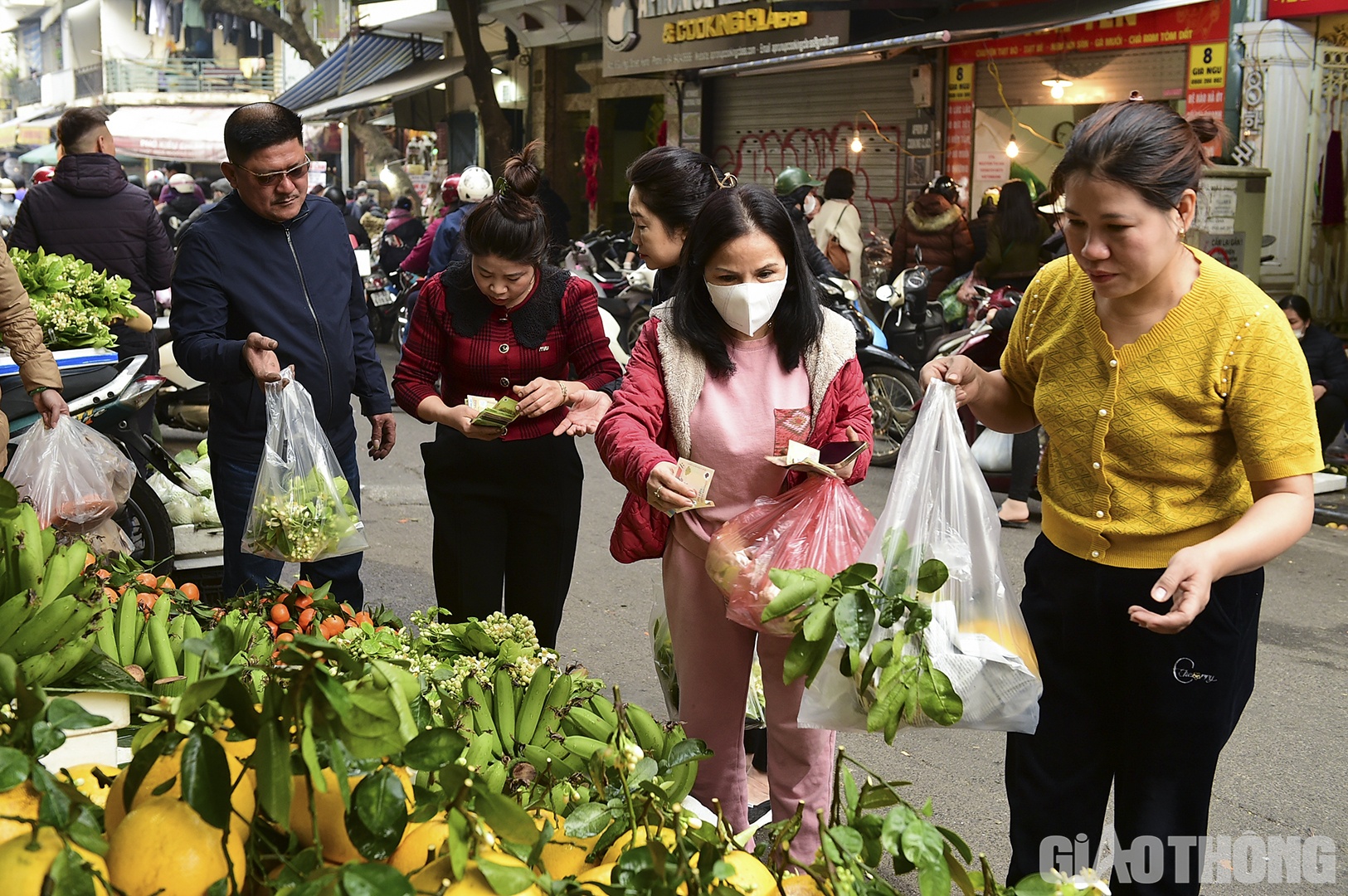 Ngoài gà luộc, nhiều loại hoa quả để lên bày mâm lễ Tết cũng được khách hàng quan tâm. Những quả bưởi có liền hoa và lá có giá 150.000 đồng/quả, trong khi những chùm hoa bưởi có giá 100.000 đến 150.000 đồng/bó.