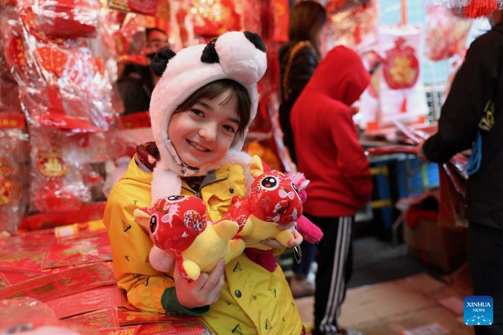 Em nhỏ tươi cười, tay ôm đồ chơi tại hội chợ mừng Tết Nguyên đán tại khu phố người Hoa ở San Francisco, Mỹ. Ảnh - Xinhua