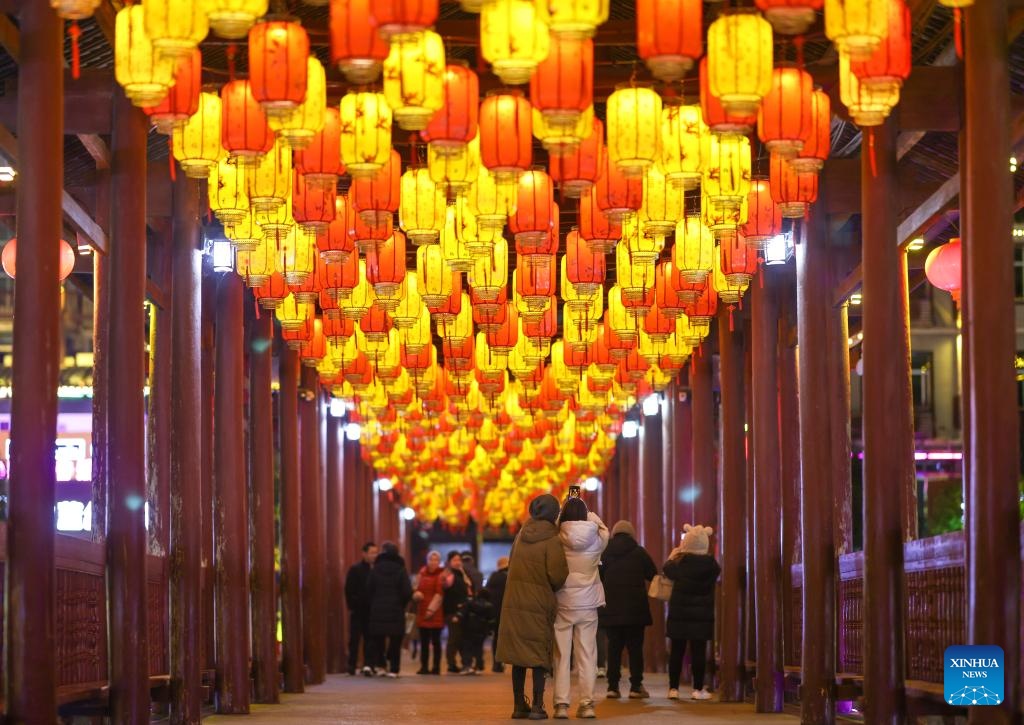 Người dân thành phố Hoài Hóa, tỉnh Hồ Nam, Trung Quốc ngắm đèn lồng trang trí mừng Tết Nguyên đán trên đường phố. Ảnh - Xinhua