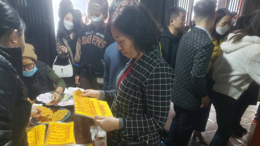 Người dân lựa chọn cho mình những tờ sớ theo nhu cầu. "Năm nay tôi mua thêm bùa với giá 20.000 đồng/cái để vào sau điện thoại mong những điều tốt luôn bên mình", chị Thu, người dân TP Nam Định cho hay.