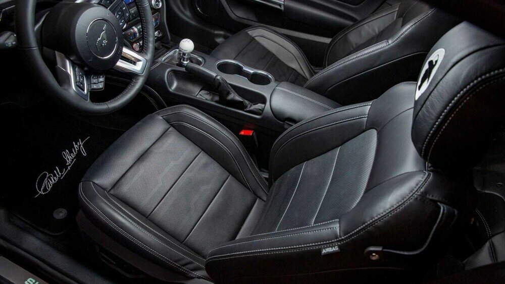 Bên trong, các tấm bệ cửa, thảm sàn và nội thất bọc da đều đi kèm với biểu tượng và huy hiệu Carroll Shelby Centennial Edition