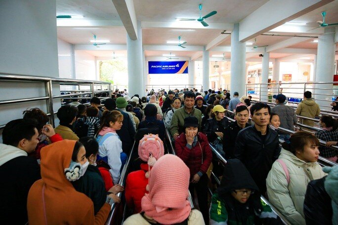 Khu vực lối vào cáp treo Chùa Hương chật kín người xếp hàng. Mất nhiều phút chờ đợi du khách mới có thể chen chân vào cabin cáp treo để lên động Hương Tích.
