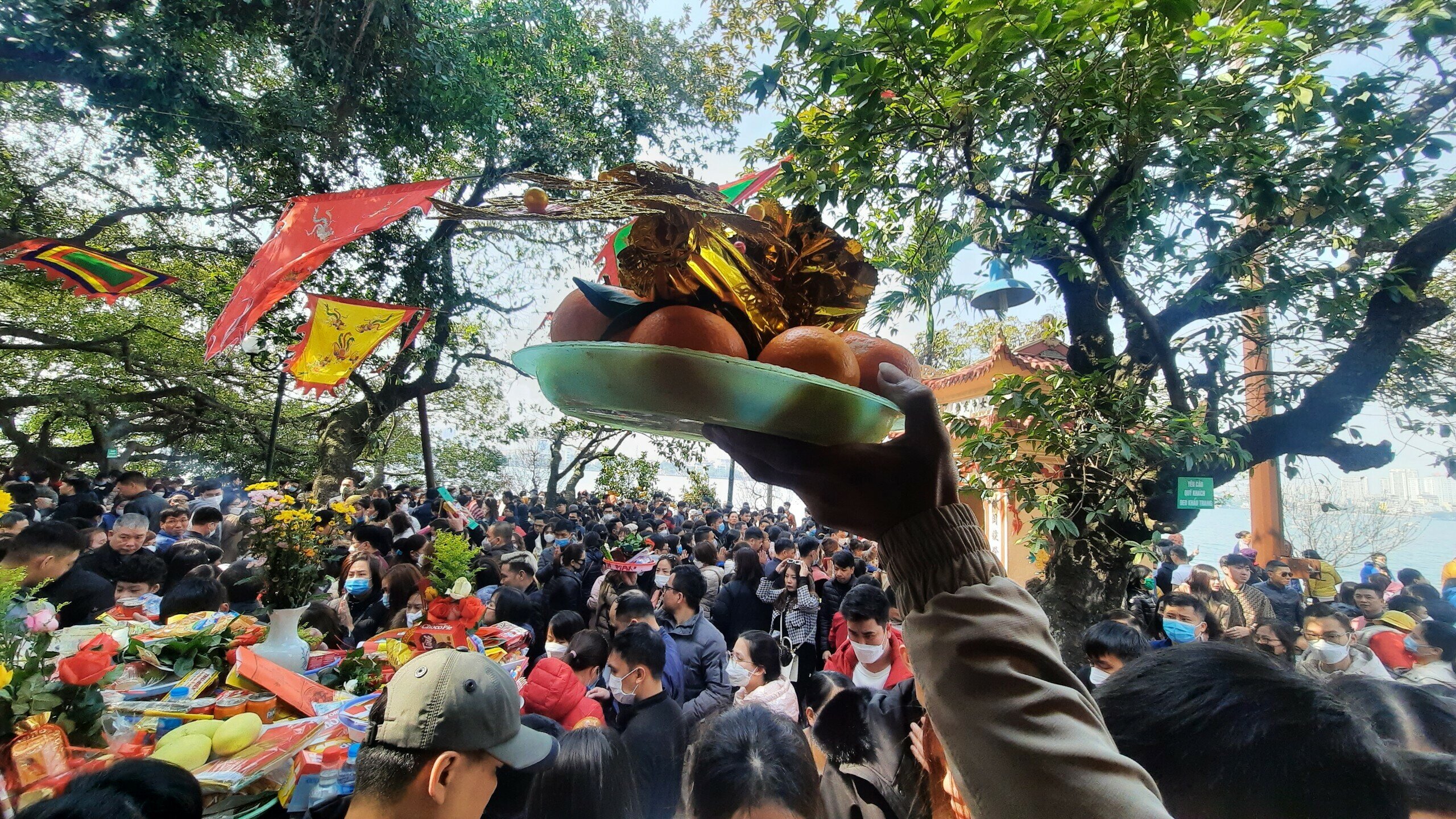 Lượng người chen kín nên để lễ vật của mình không bị rơi, không ít người đã chọn cách đưa lên cao qua đầu.