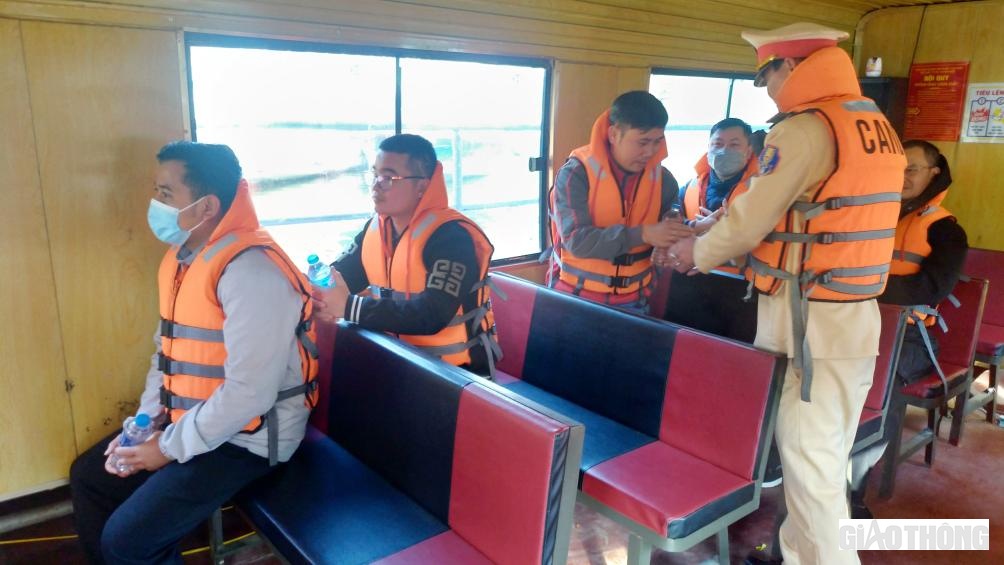 Cán bộ chiến sĩ CSGT phát nước hỗ trợ người dân khi đi tham quan trải nghiệm du lịch hồ Thác Bà được đảm bảo ATGT.