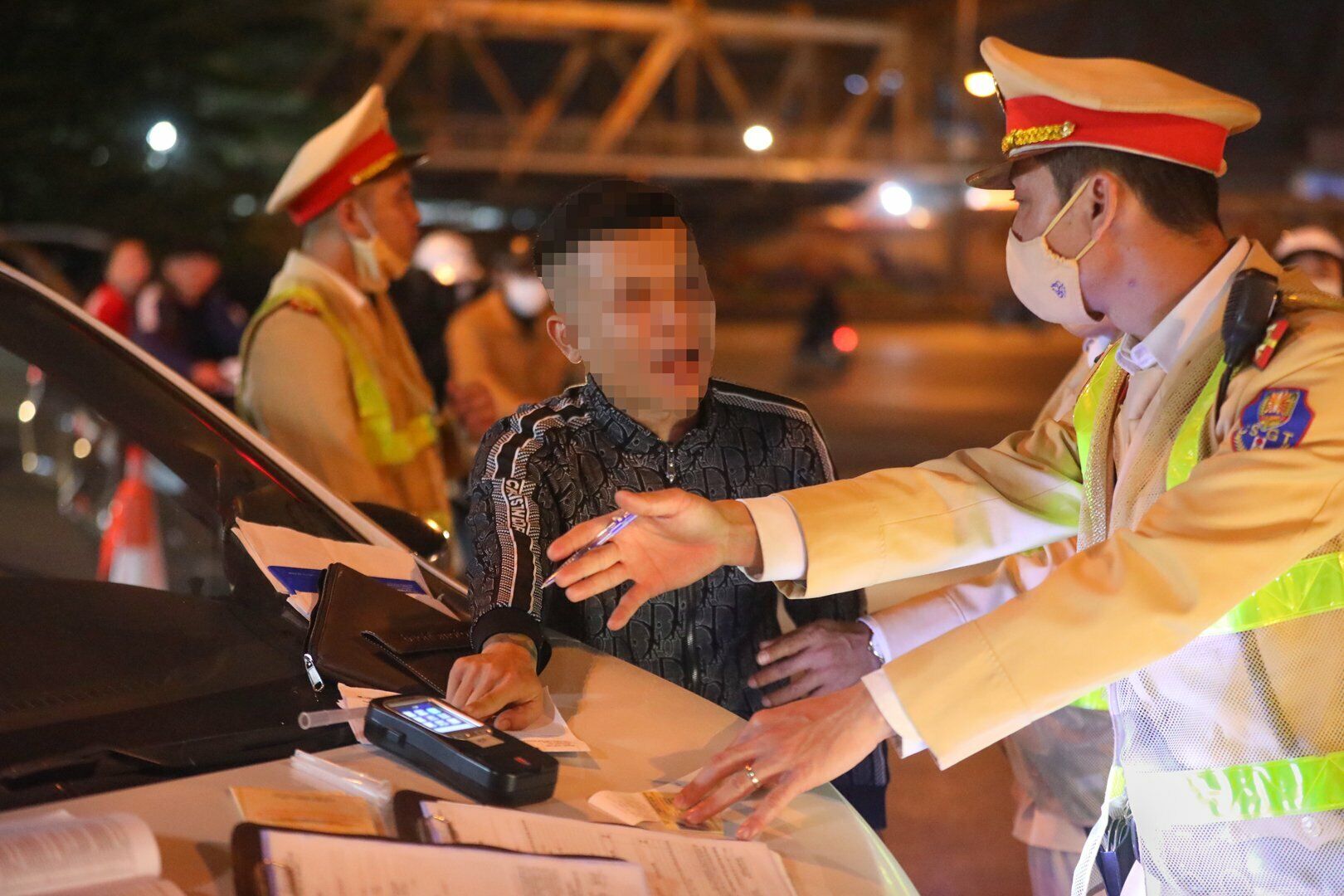 Đến lúc này, tài xế H. thể hiện thái độ không hợp tác, không ký vào phiếu đo nồng độ cồn, và yêu cầu một cán bộ Tổ công tác thổi nồng độ cồn để kiểm tra máy có đúng hay không.