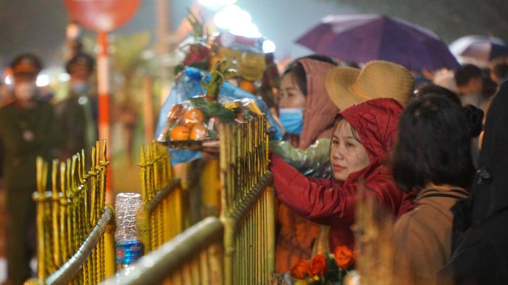 Nhiều người dân đội mưa đứng ngoài barie thâu đêm để chờ đến thời điểm được vào dâng hương, làm lễ tại đền Trần.