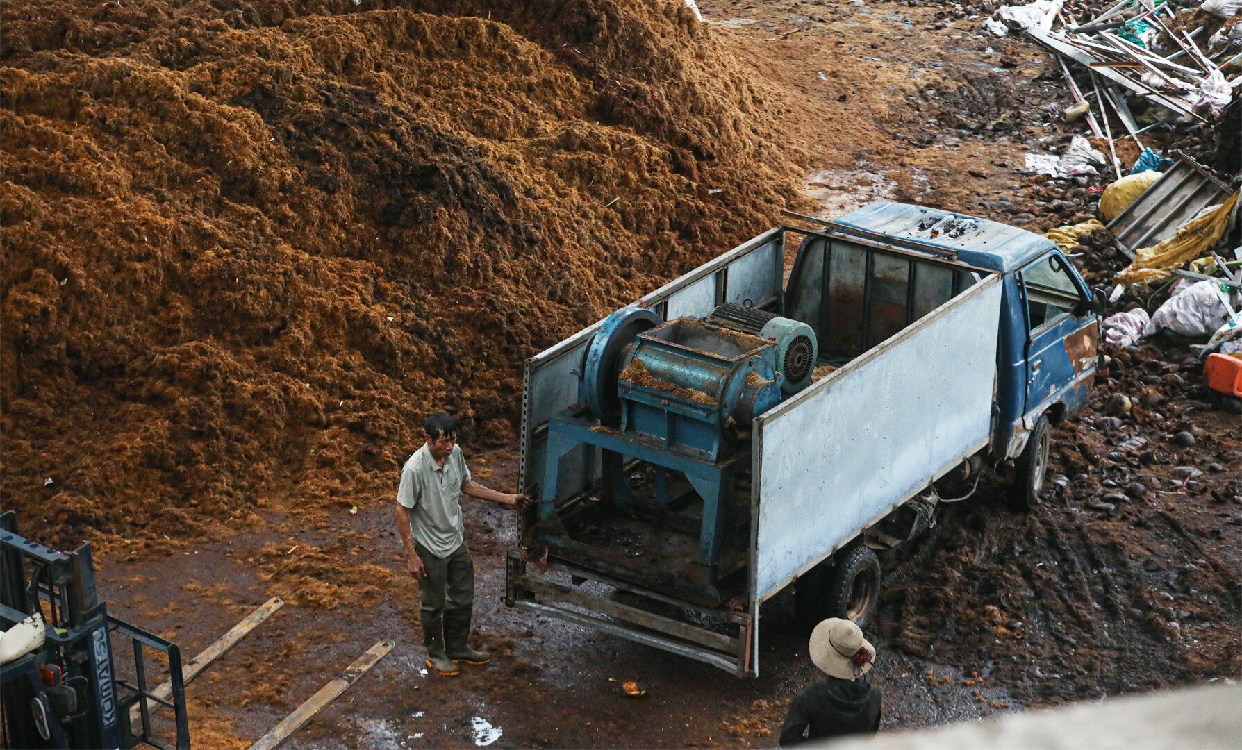 Dưới chân cầu, rất nhiều xưởng sản xuất xơ dừa với những đống xơ chất cao gần đến mặt dưới của cầu Thăng Long.