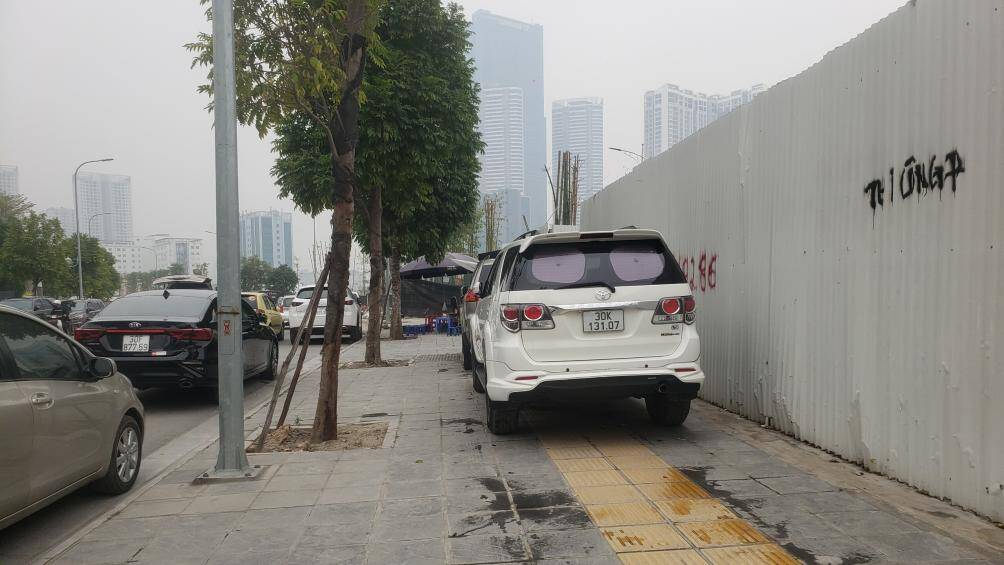 Xe ô tô đỗ chiếm hết cả vỉa hè con đường mới mở.