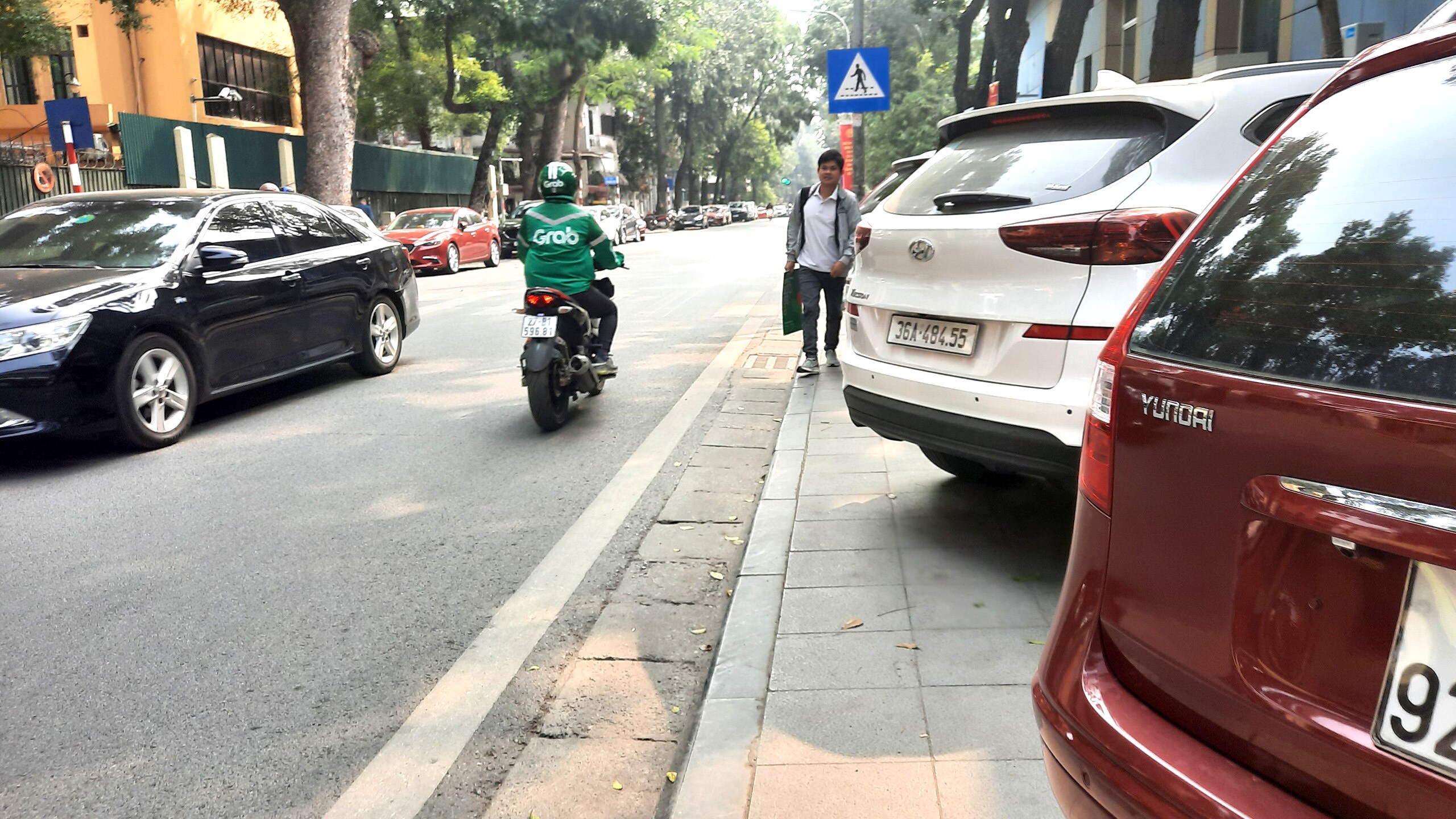 Nhiều người muốn đi bộ qua đây phải nghiêng người, luồn lách qua những chiếc ô tô mới có thể đi được.
