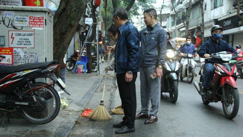Tổ công tác nhắc nhở việc chủ cơ sở tập kết rác dưới lòng đường.