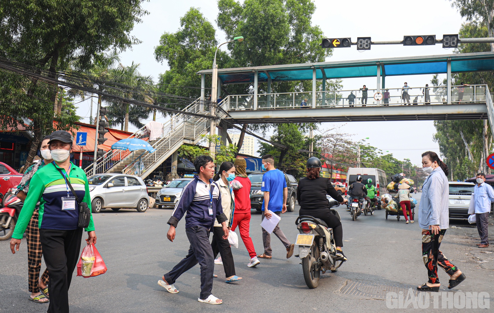 Theo ghi nhận của PV Báo Giao Thông trong chiều 6/3 trước cổng Bệnh viện K cơ sở Tân Triều, dù cầu bộ hành được xây dựng cách đó không xa nhưng nhiều người vẫn lựa chọn đi bộ dưới lòng đường.