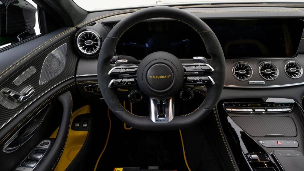 Vô lăng thể thao đặc trưng Mercedes-AMG bọc da Nappa và Dinamica được giữ lại. Mansory đã tạo điểm nhấn bằng các đường chỉ khâu nổi màu vàng