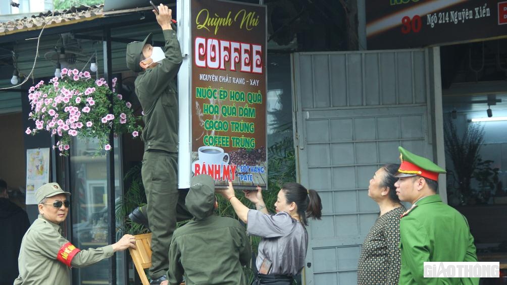 Người dân tại cửa hàng COFFEE "xin" không hạ biển nhưng với sự kiên quyết, tổ công tác vẫn huy động người để tháo dỡ.