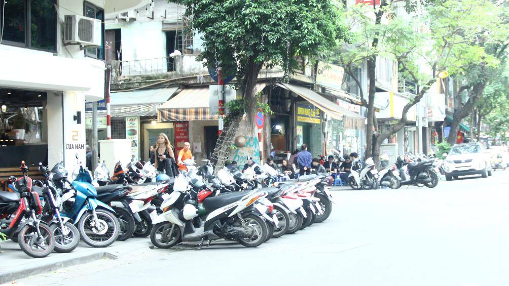 Tại một quán cà phê ở Cửa Nam, xe máy của khách được đỗ hết trên vỉa hè, thậm chí còn có hàng dài xe máy đỗ dưới lòng đường.