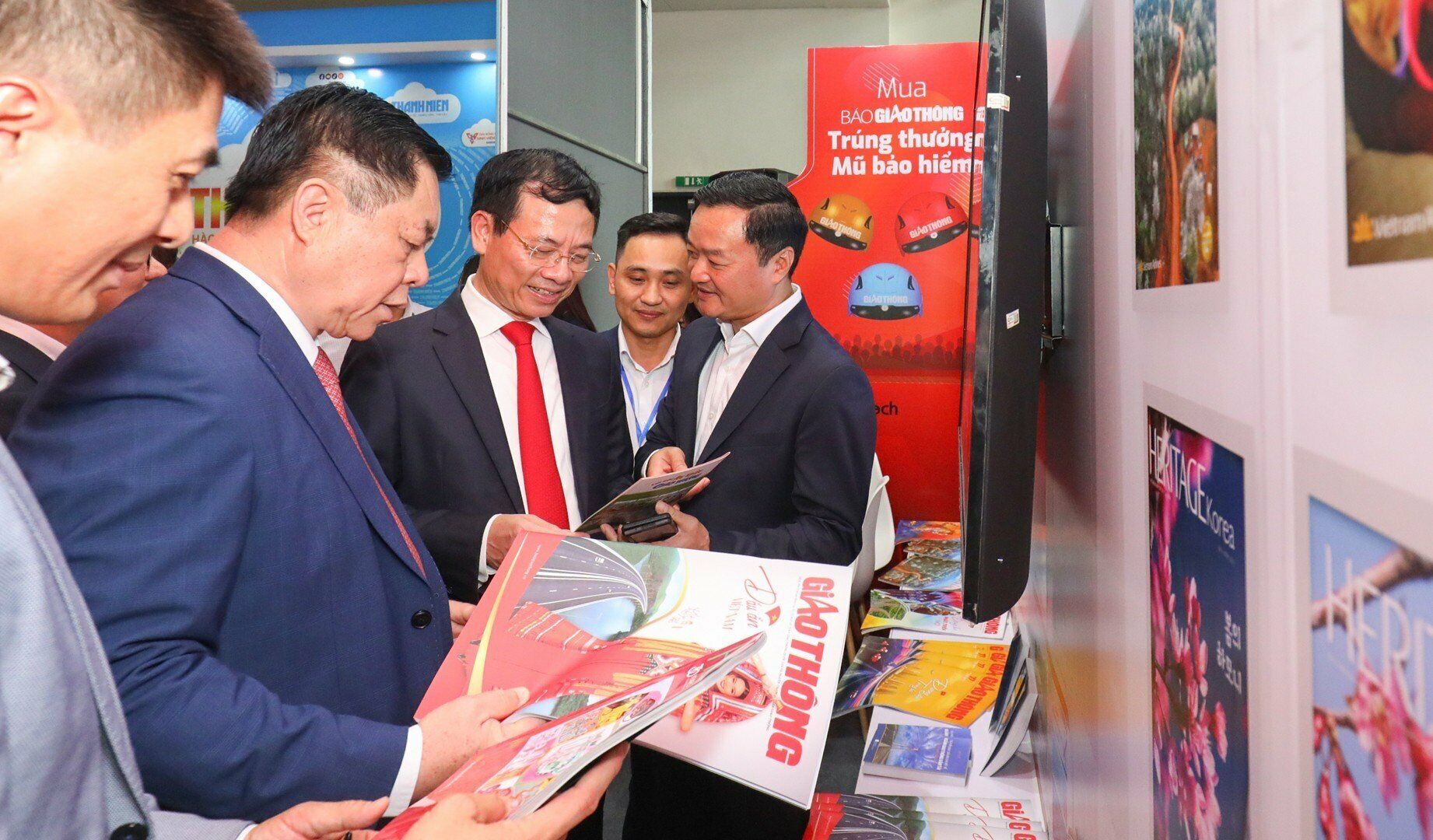 Trưởng Ban Tuyên giáo Trung ương Nguyễn Trọng Nghĩa và Bộ trưởng Bộ Thông tin và truyền thông Nguyễn Mạnh Hùng quan tâm đến những ấn phẩm của Báo Giao thông.